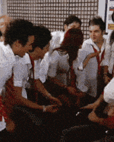 a group of people are sitting in a circle and one of them is pointing at another person