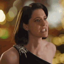 a woman in a black dress making a funny face