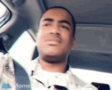 a man is sitting in the back seat of a car looking up at the sky .