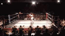 a wrestling ring with a few people watching and a sign that says ' tokyo ' on it