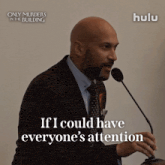 a man speaking into a microphone with the words " if i could have everyone 's attention "