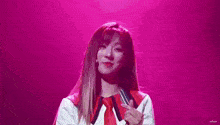 a woman is holding a microphone on a stage in front of a purple background .