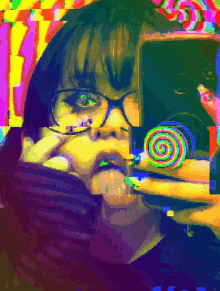 a girl with glasses is holding a colorful lollipop