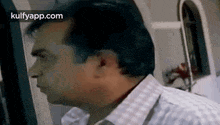a man in a plaid shirt is looking at the camera .