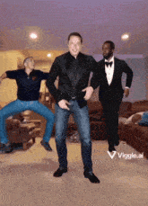 a man in a tuxedo is dancing in a living room with two other men