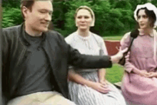 a man with a cast on his arm is being interviewed by a group of people .