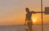 a woman is standing in the ocean holding a surfboard .