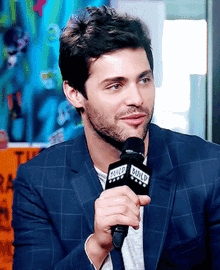 a man in a suit is holding a microphone that says wild