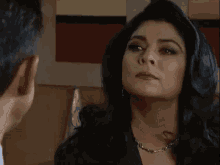 a woman is smiling and looking at the camera while a man is behind her .