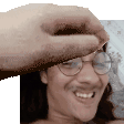 a man with glasses and a mustache is smiling while a hand is holding his head .