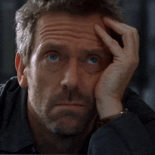 a close up of a man 's face with his hand on his face