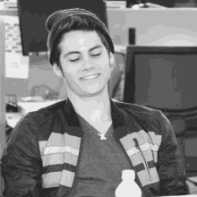 a man wearing a beanie and a striped jacket smiles