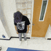 a person wearing a t-shirt that says alliance is standing in front of a door