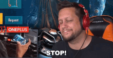 a man wearing red headphones is sitting in front of a oneplus sign