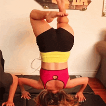 a woman is doing a handstand in front of a sign that says " california "