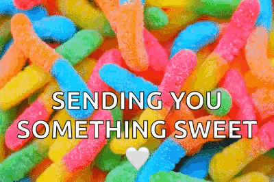 a pile of colorful gummy worms with the words `` sending you something sweet ''