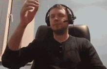 a man wearing headphones and a headset is sitting in a chair