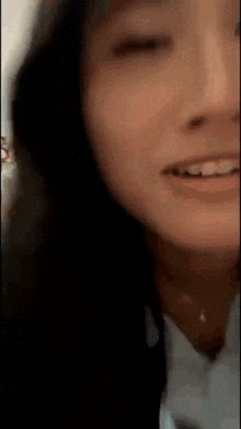 a close up of a woman 's face with her eyes closed smiling .