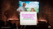 a man and woman are standing in front of a screen that says nbc