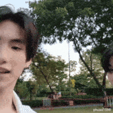 two young men are standing in a park with the name phuaa1599 on the bottom right corner