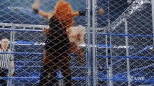 a wrestling match is taking place in a cage with a referee .