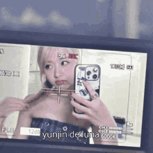 a woman is taking a picture of herself in a mirror with yunjin de luna written below it