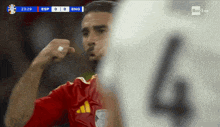 a soccer player wearing a red jersey with the number 4 on the back
