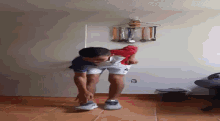 a young man is stretching his legs in a room with trophies hanging on the wall