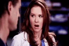 a man and a woman are standing next to each other and the woman is making a funny face .