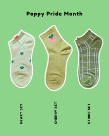 three pairs of socks are lined up on a green background with the words poppy pride month written above them
