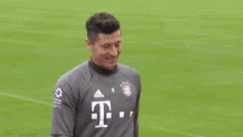 a soccer player is standing on a soccer field wearing a t-mobile jersey .