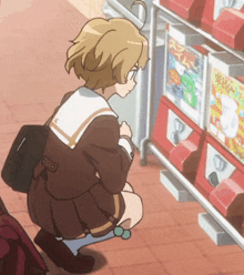 a girl in a school uniform is kneeling down in front of a vending machine that says ' a ' on it