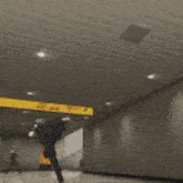 a man in a black suit is jumping over a yellow tape with the number 435-2345 on it