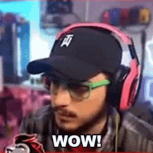 a man wearing headphones and a hat is saying wow !