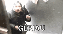 a woman with a scarf on her head is walking down a hallway and the word gerau is on the bottom