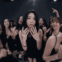a woman in a black dress is surrounded by other women in black dresses