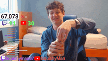a man is holding a can of soda in front of a screen that says squishyman