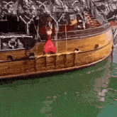 a mermaid is hanging from the side of a pirate ship that says ' pirate ' on it