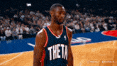 a basketball player for the theta team stands on the court