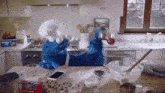 cookie monster in a kitchen with a box of chocolate chip cookies