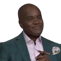 a man wearing a green suit and a pink shirt smiles