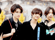a group of young people standing next to each other with one wearing a black shirt with a blue strap that says " k "