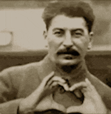 a man is making a heart shape with his hands
