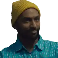 a man wearing a yellow beanie and a blue shirt is smiling