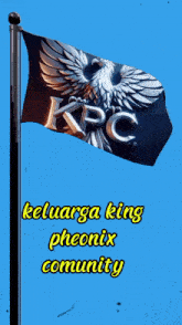 a kpc flag is flying in the wind against a blue background