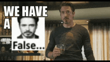 a man holding a glass in front of a sign that says we have a false on it
