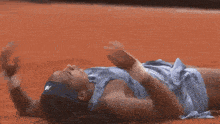 a woman in a blue tank top is kneeling on the ground