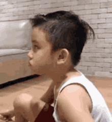 a young boy is sitting on the floor looking at something .