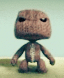 a stuffed animal with a zipper on its chest is sitting on a table .