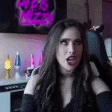a woman is sitting in a chair with her mouth open in front of a tv .